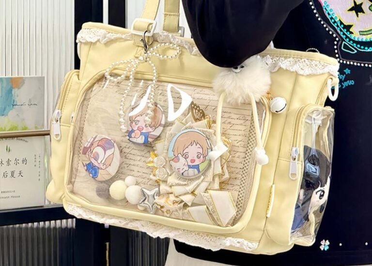ita bag: what it is and 7 must-have customization ideas - laptop bag ita bag with clear window showing enamel pins, acrylic standees, and a pastel backing insert