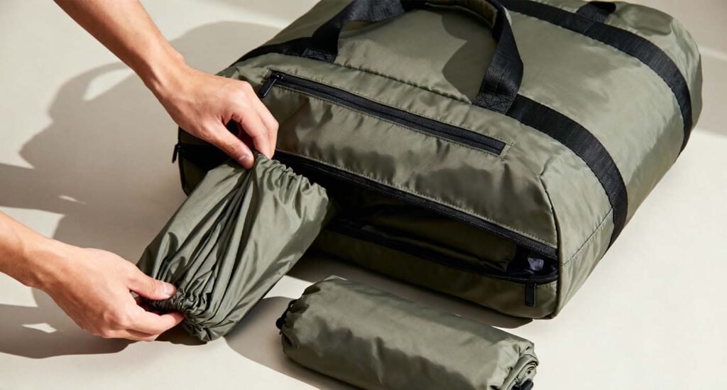 The Complete Foldable Travel Bag Guide: Space-Saving Travel Solutions - laptop bag Hands unfolding a foldable travel bag from a small pouch into a full-size bag.