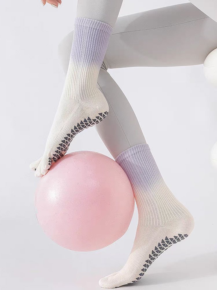Purple Gradient Five-Toe Pilates Socks worn during a ball exercise.