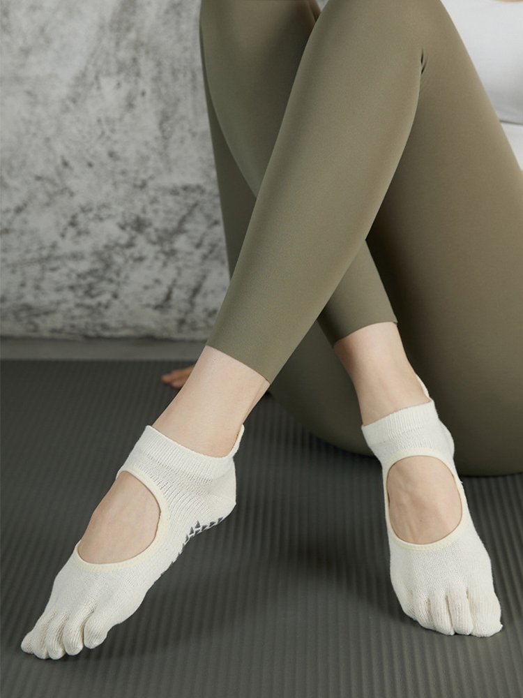Front view of a model wearing open-top ballet-style five-toe grip socks.