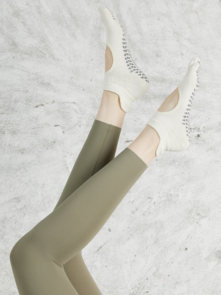 Profile view of feet raised in the air wearing five-toe grip socks for Barre.